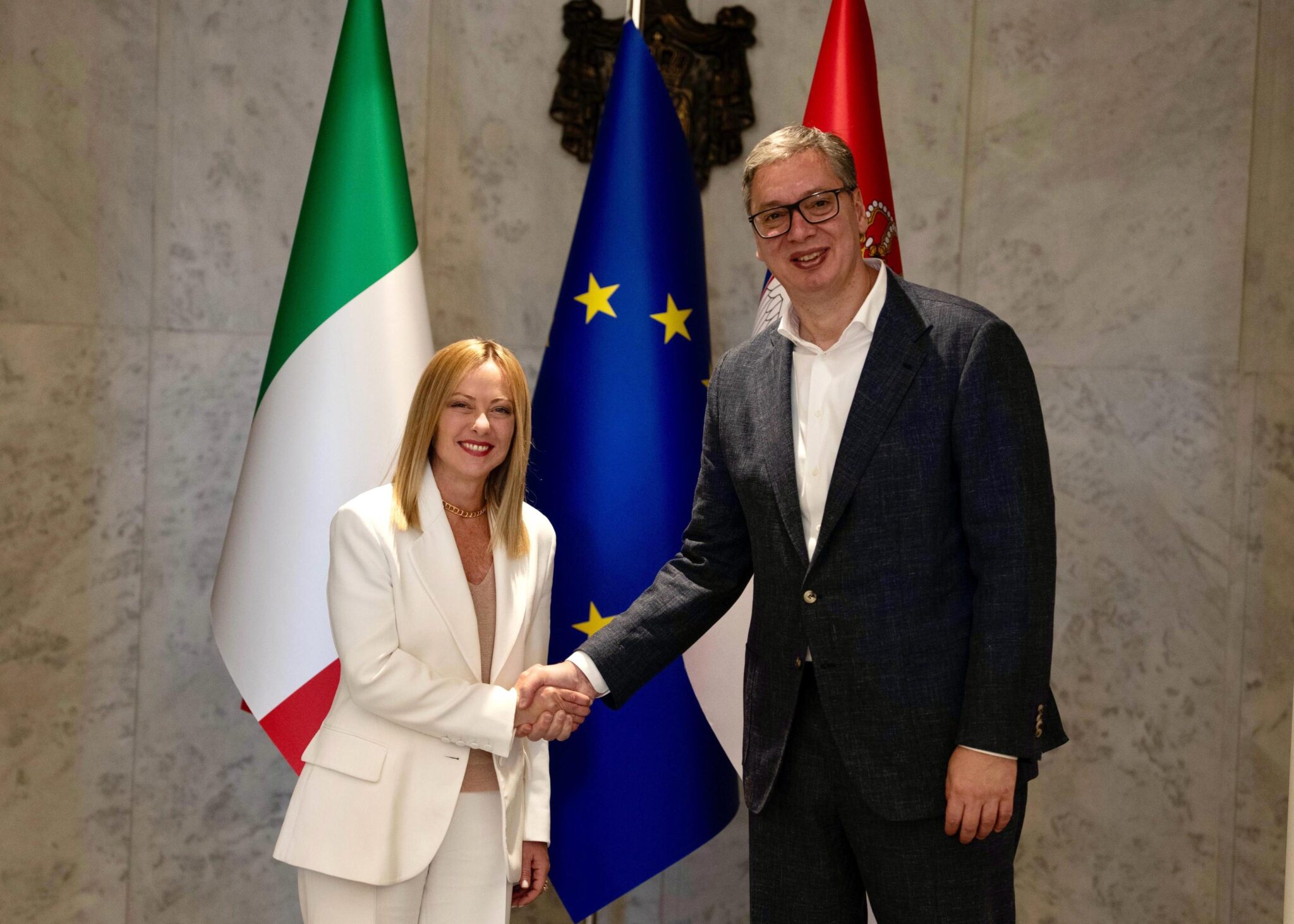 Serbian President Aleksandar Vucic (R) shaking hands with Italian Prime Minister Giorgia Meloni (L)